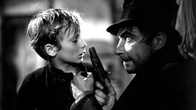 Oliver is menaced by Bill Sykes in Oliver Twist