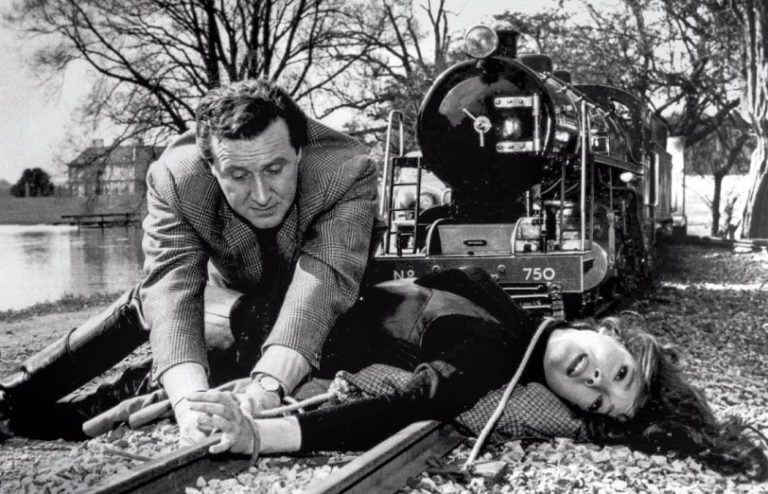 Steed tries to release Mrs Peel who is tied to the railway track