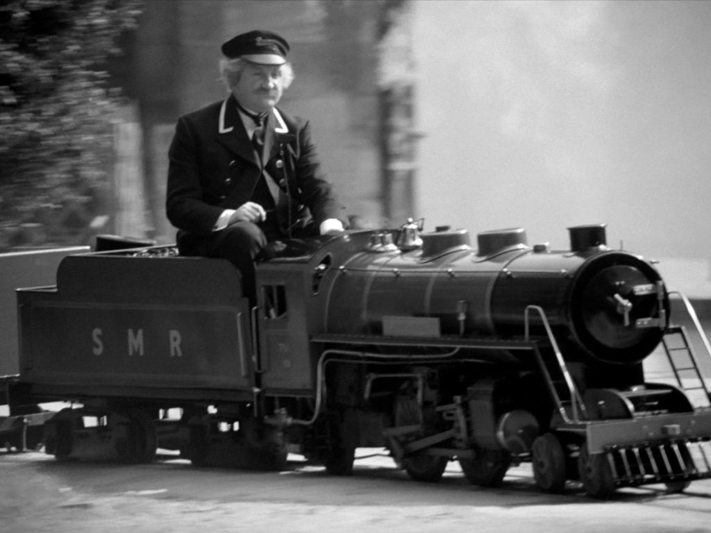 Ronald Fraser dressed as a train driver on board a miniature train