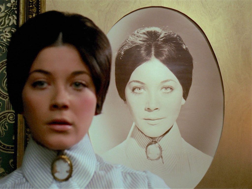 Tara King in front of a portrait of Pandora
