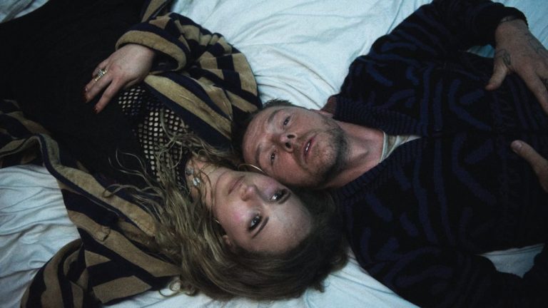 Juno Temple and Simon Pegg lying in the snow