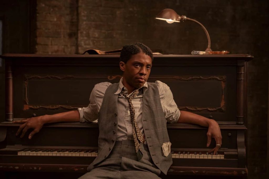 Levee (Chadwick Boseman) leans back against the piano