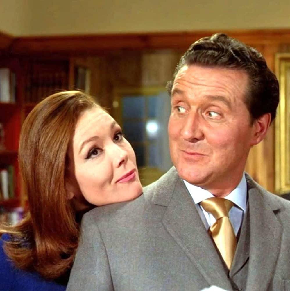 Emma Peel rests her chin on John Steed's shoulder