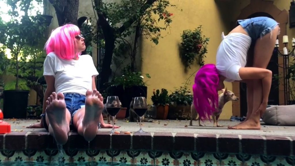 Two unidentified actors do yoga by the pool