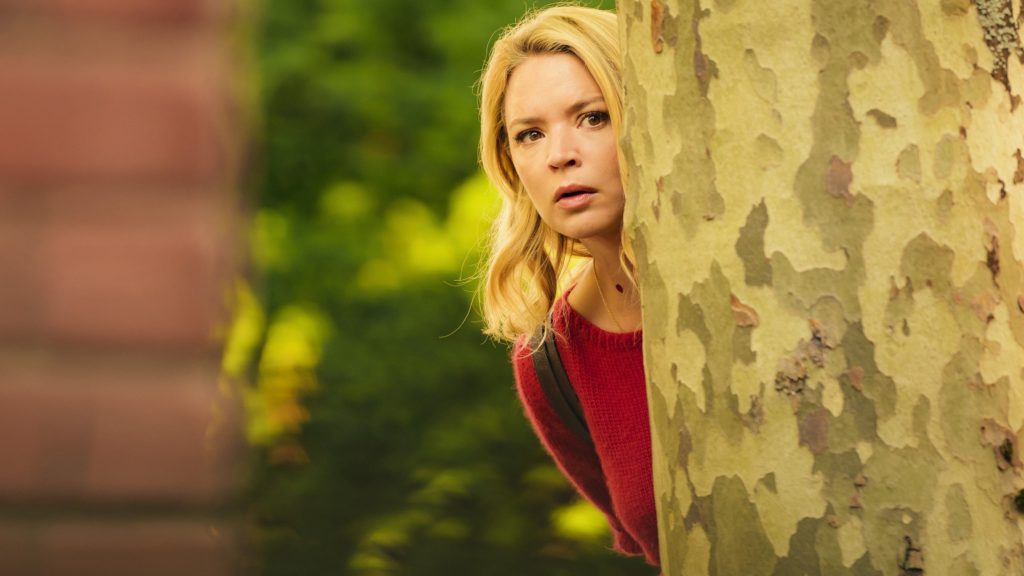 Suze peers from behind a tree