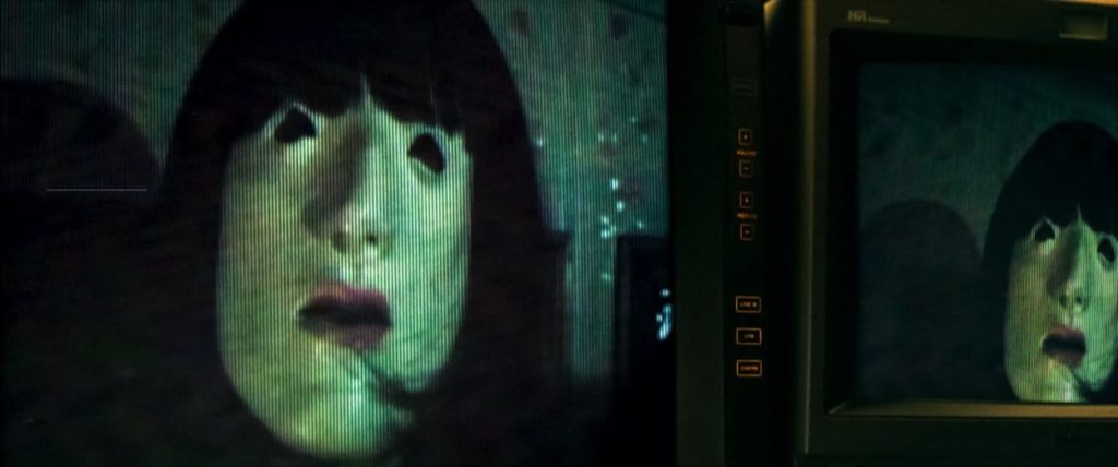 A black haired figure interrupts a broadcast