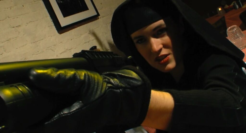 Sister Wrath in habit, with gun