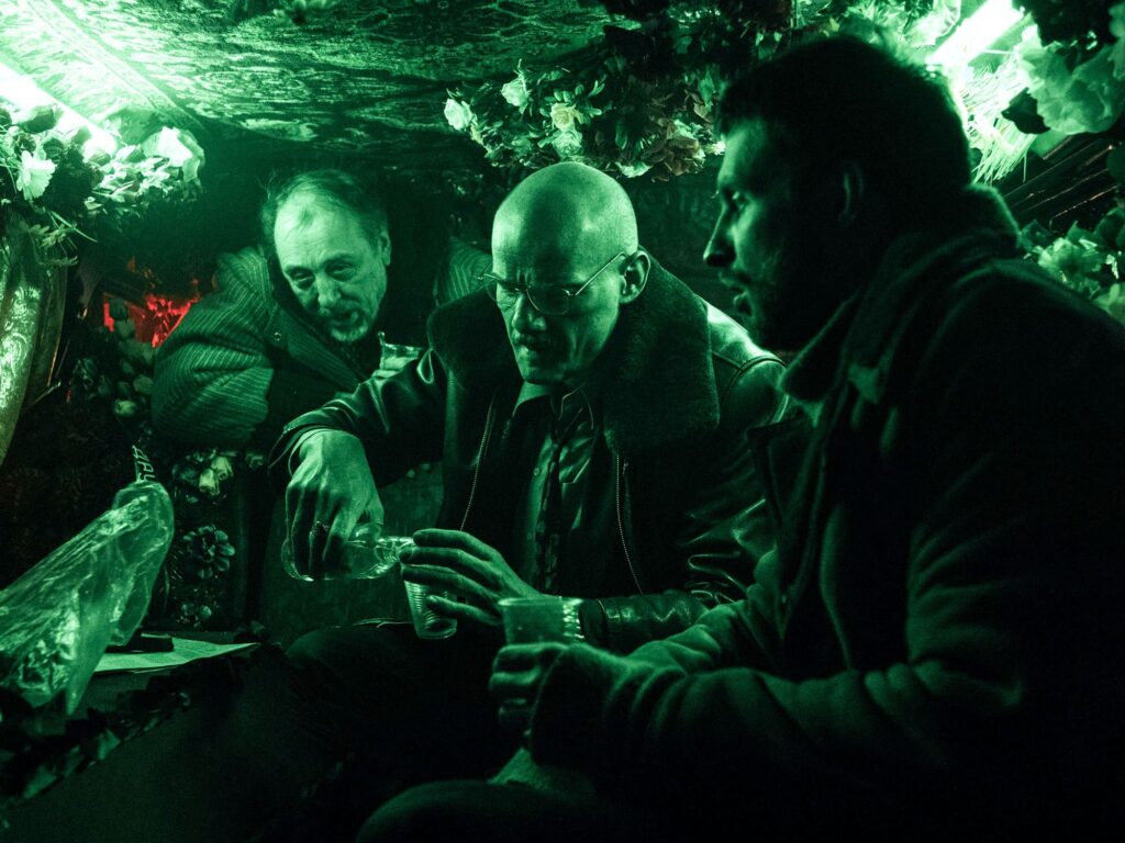 Petrov in the van with the men transporting the coffin
