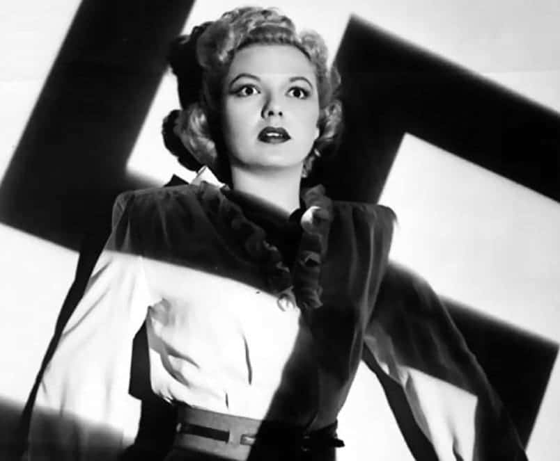 Marjorie Reynolds as Carla, with a swastika projected over her