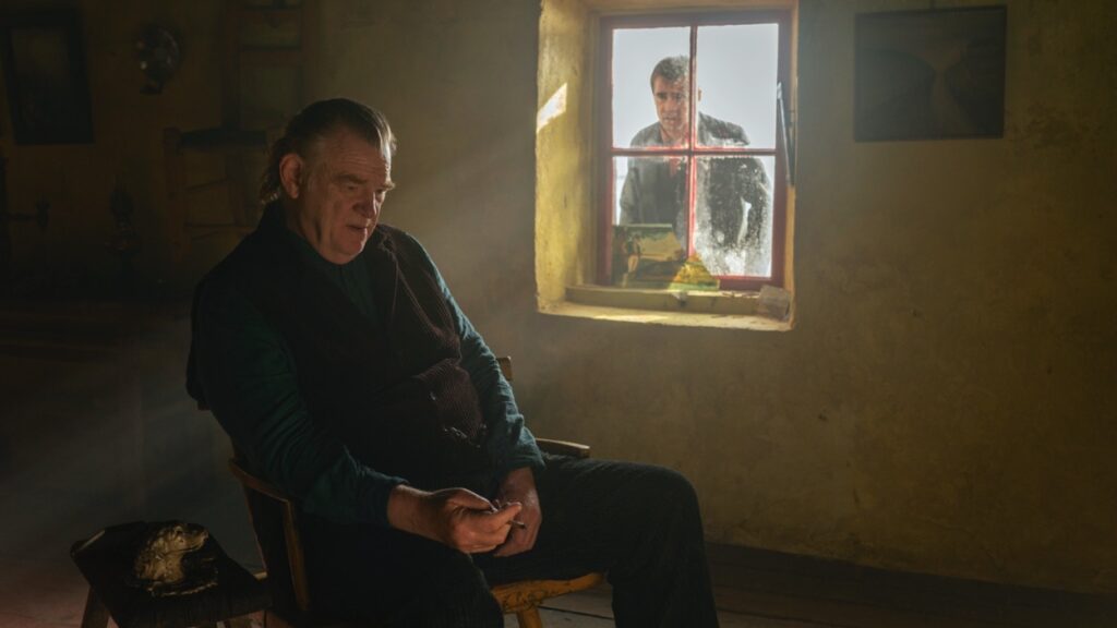 Colm sits while Pádraic broods outside at the window