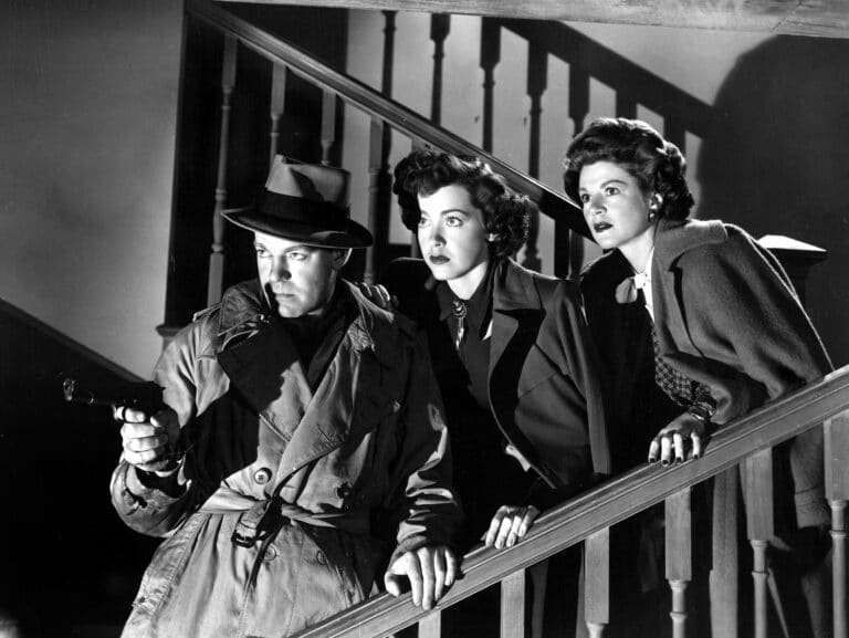Joe with gun, and Ann and Pat on a staircase