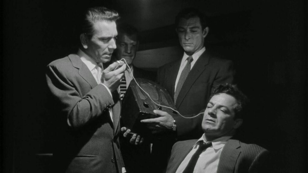 Brown (left) tortures Diamond (right) with a hearing aid