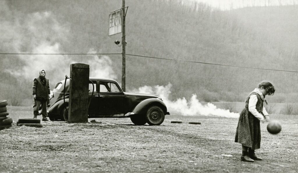 A typically bleak composition of car and playing child
