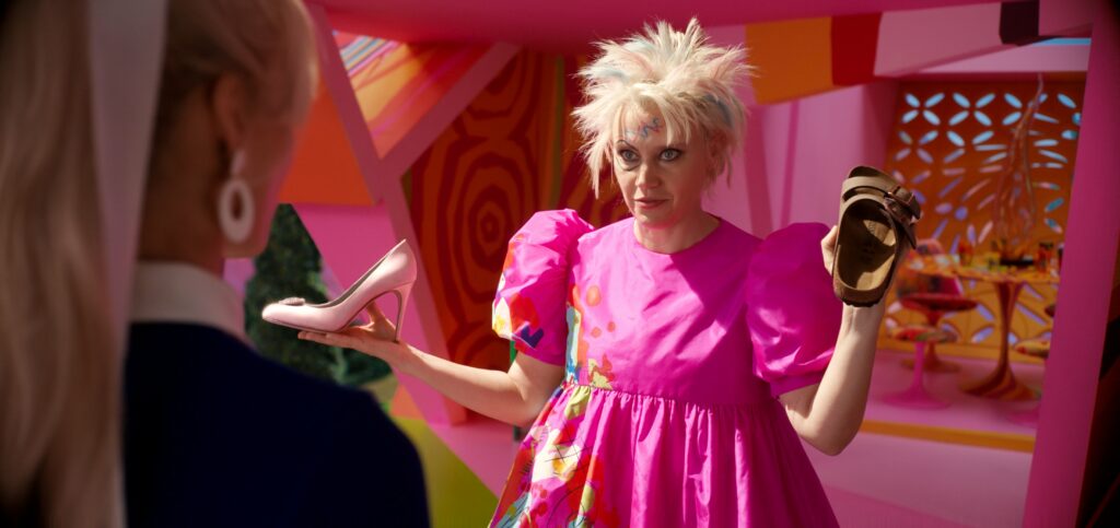Kate McKinnon's Barbie with a stiletto shoe and a Birkenstock