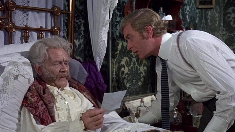 John Mills in bed and Michael Caine standing over him