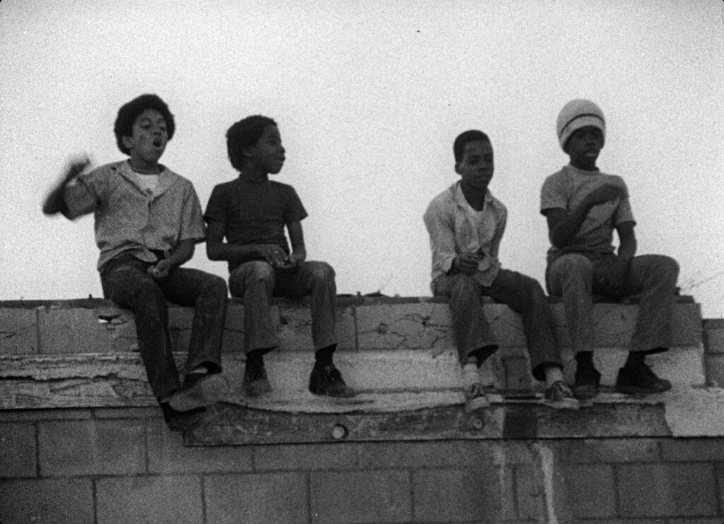 Four kids sit on a roof