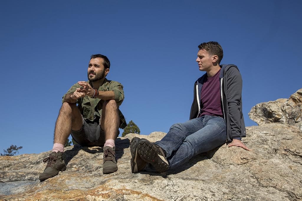 Agustín and Patrick sit on a hillside