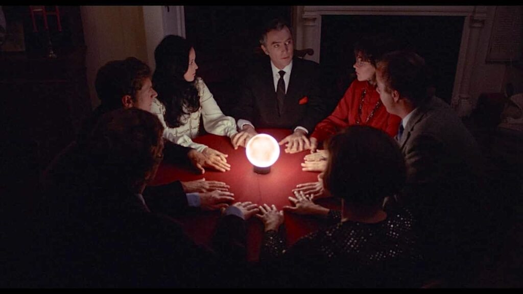 The leads a seance in a darkened room