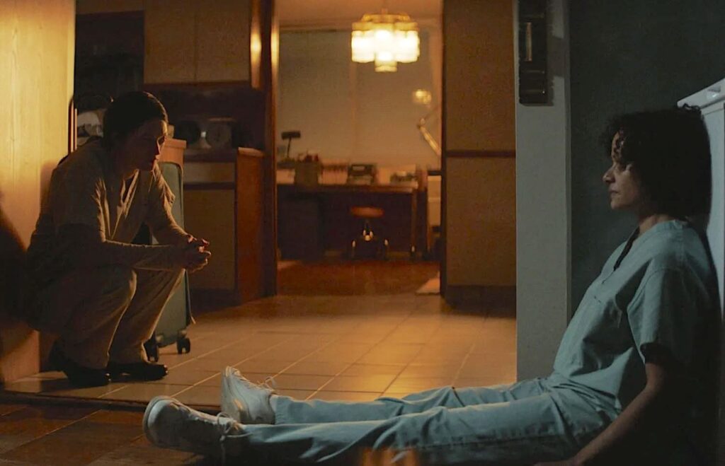 Rose and Celie sit opposite each other on the floor