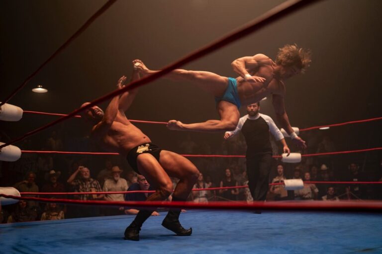Kevin flies through the air towards an opponent in the ring