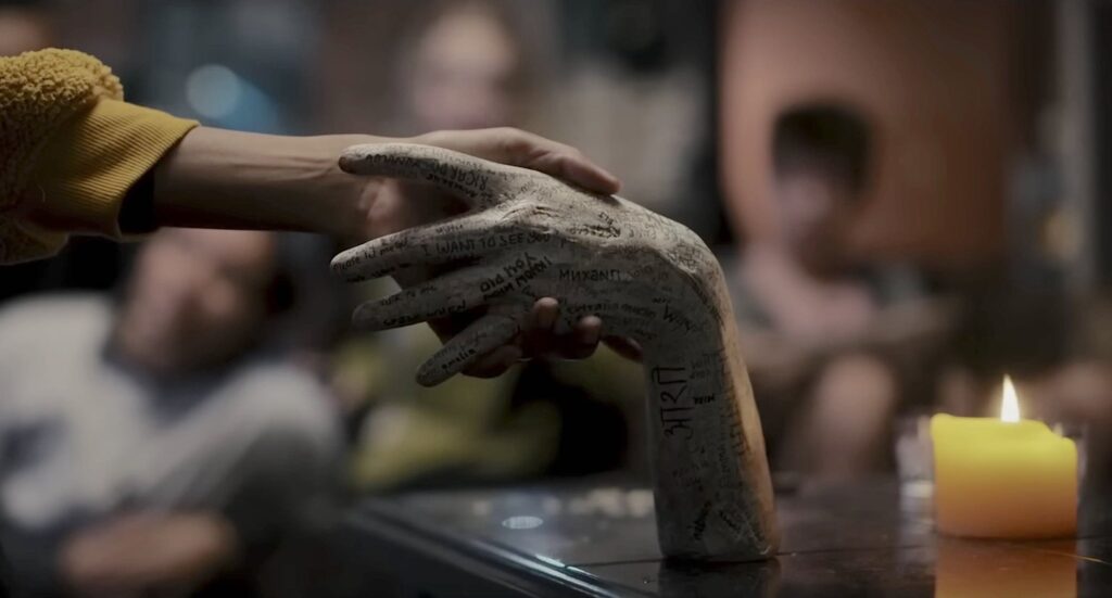 A disembodied hand grabs the porcelain hand