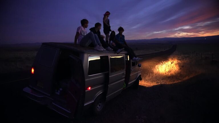 The guys on the roof of their van in the dark