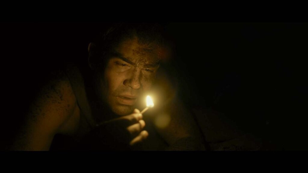 Lieutenant Berton in the dark with a lit match