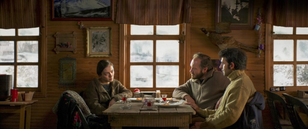Nuray, Samet and Kenan sitting at a table