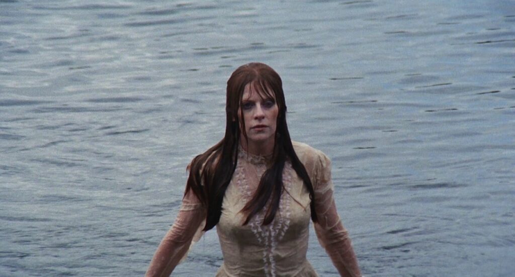 Emily walking out of a lake fully clothed