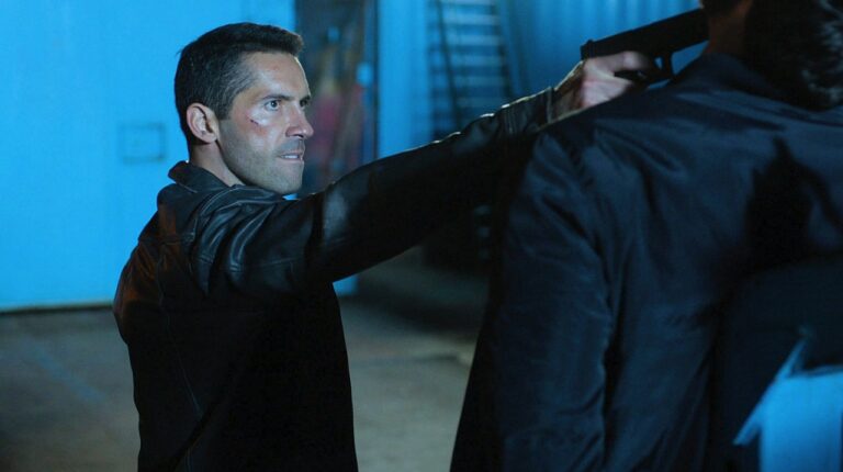 Scott Adkins points a gun