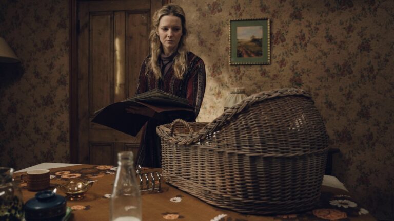 Juliette stares at a wicker crib