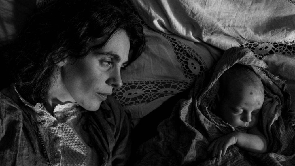 Karoline in bed next to a baby