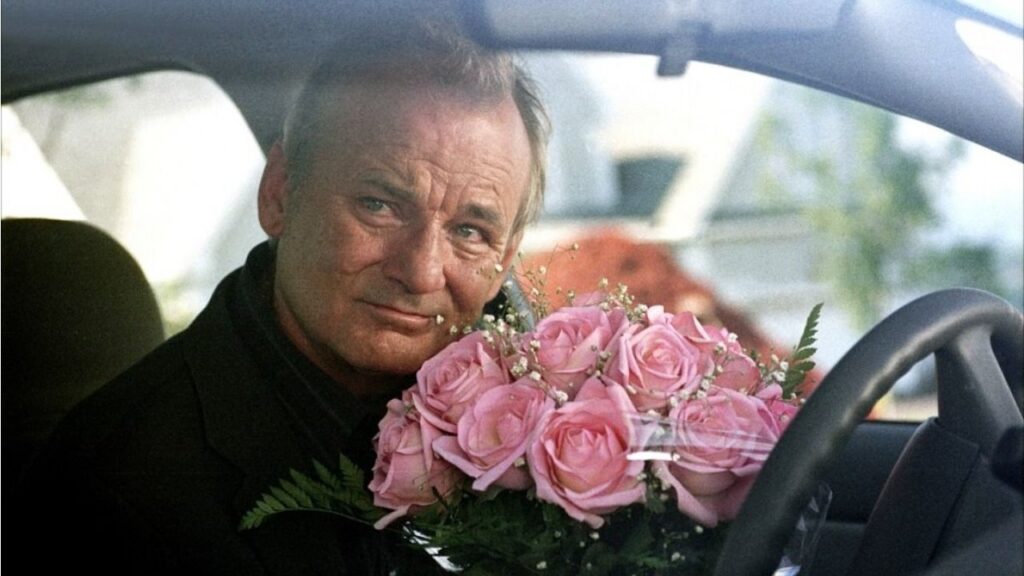 Don in his car with a bunch of pink flowers