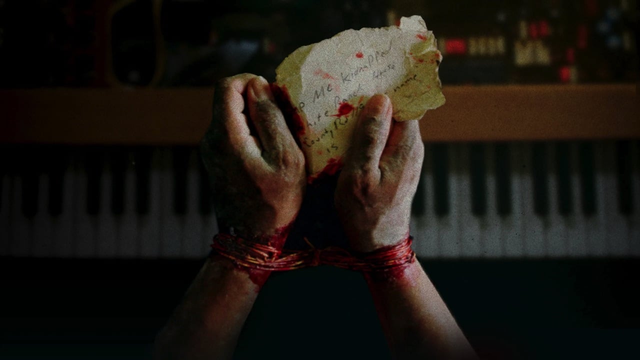 A pair of bound hands holding a piece of paper begging for help