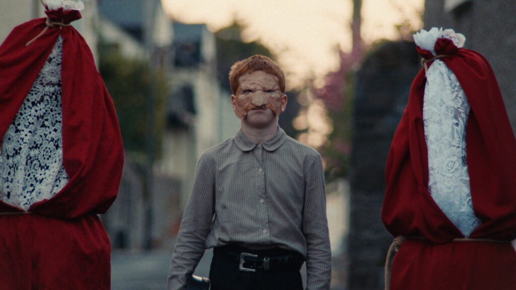 A red-haired kid in a pagan mask
