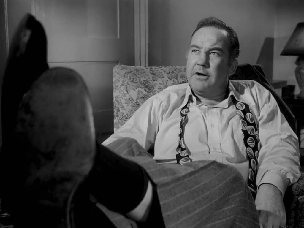 Willie Stark sprawling in a chair