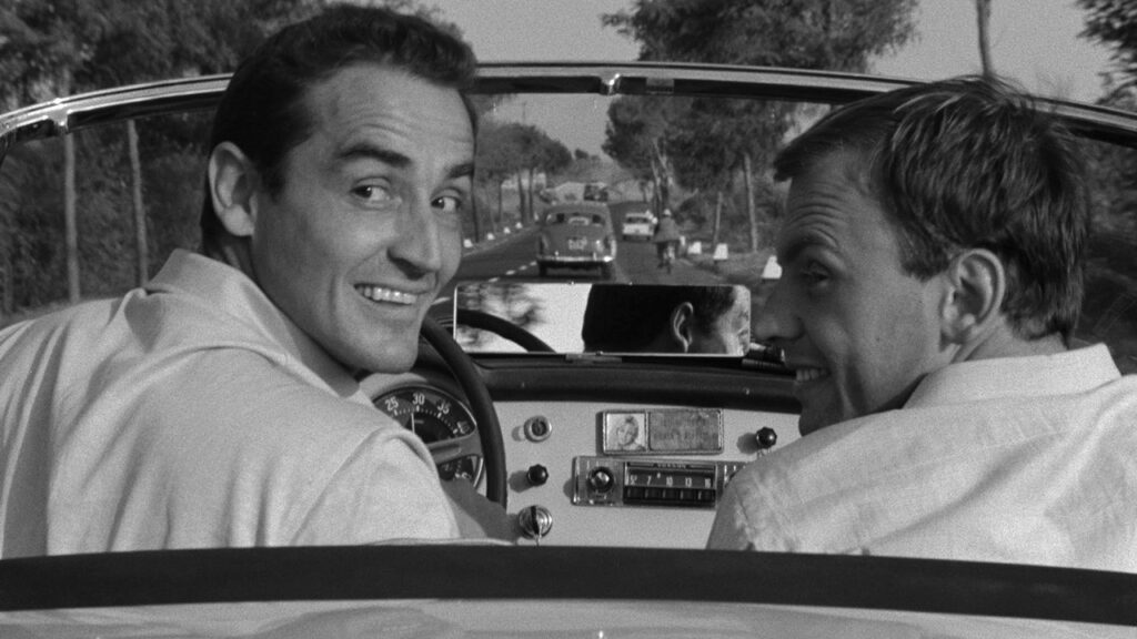 Bruno and Roberto looking backwards from the front seat of a car