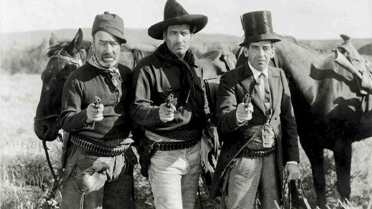 The three bad men point their guns at the camera