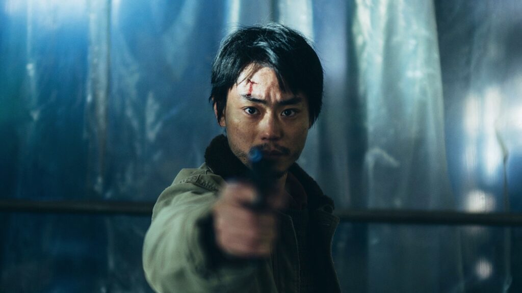 Yoshii with a gun pointing towards the camera