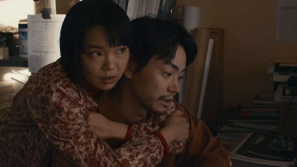 Akiko with her arms around Sano