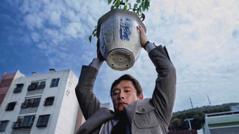 Man-su with a heavy plant pot he's ready to drop on someone's head
