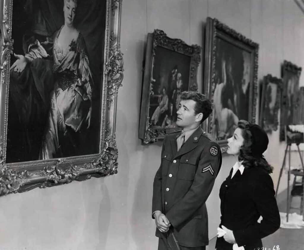 Joe and Alice look at pictures in a gallery