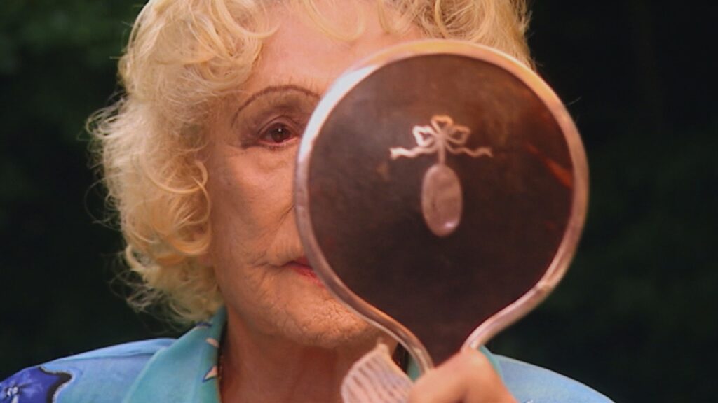 An elderly Riefenstahl gazes into a mirror