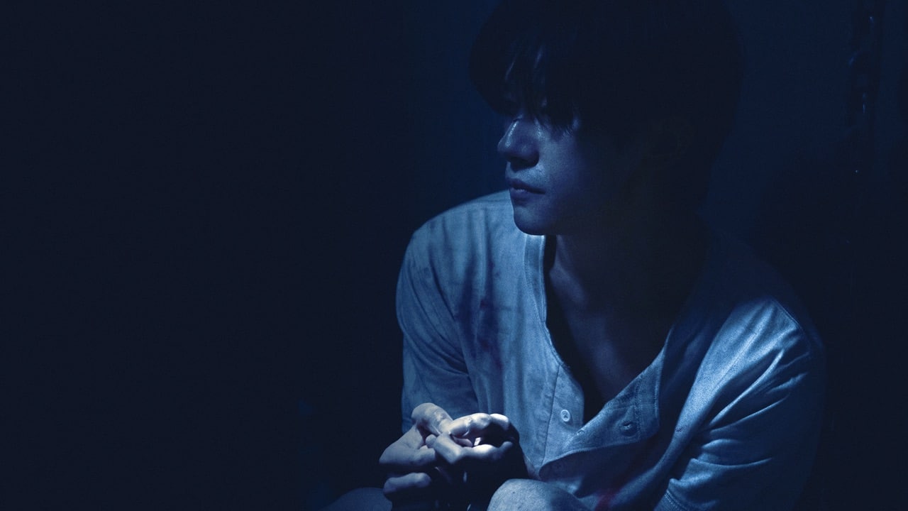 Moody shot of Jackson Yee almost enveloped in shadow
