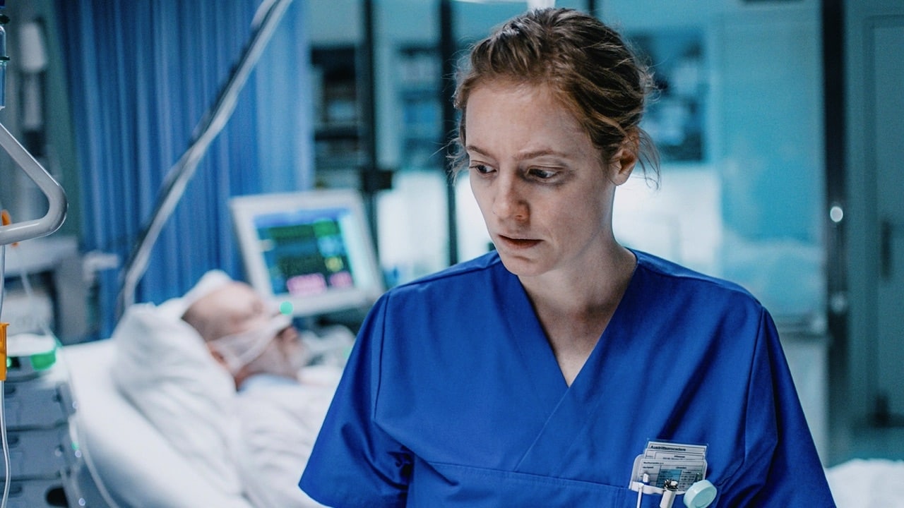 Floria in uniform in front of a patient's bed