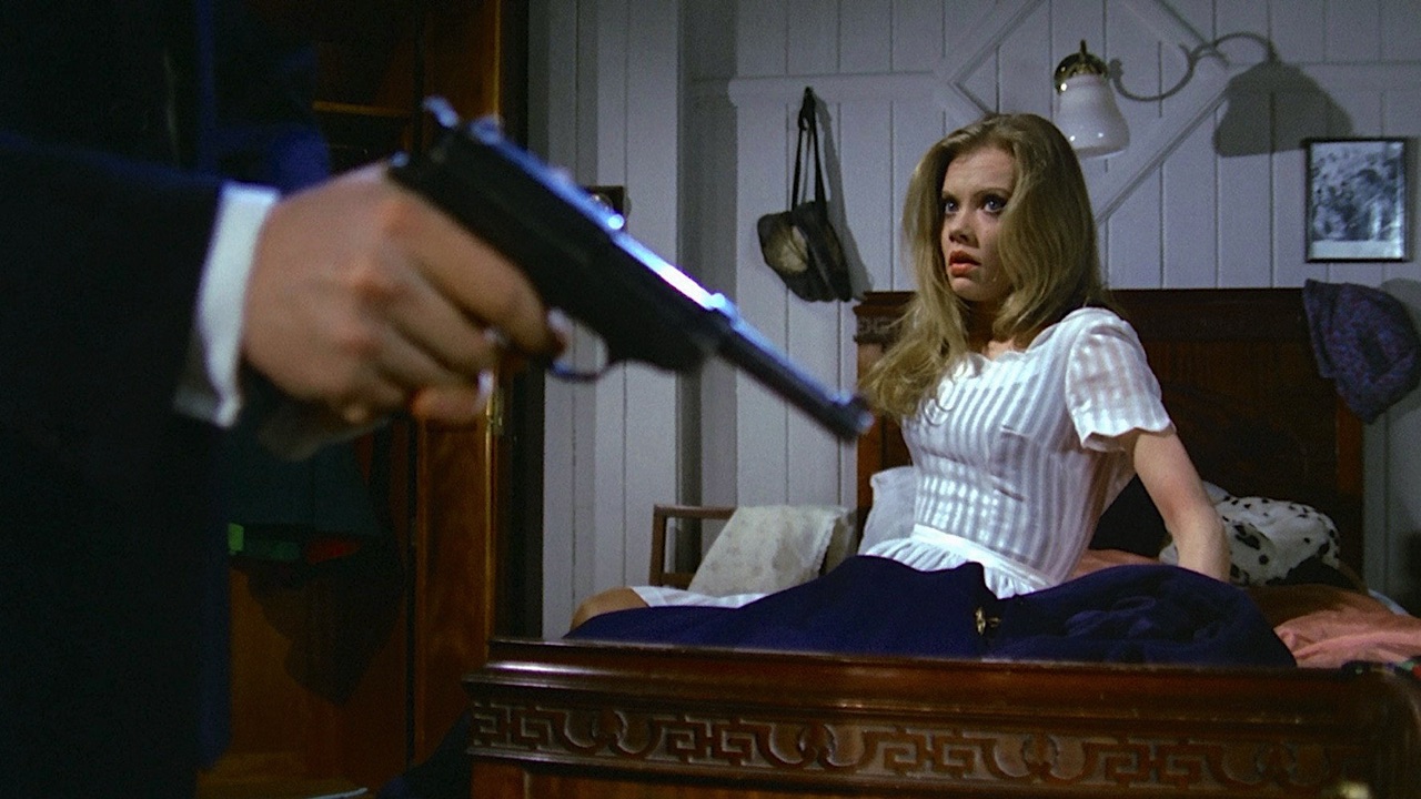 A disembodied hand loads a gun while a frightened Susan cowers
