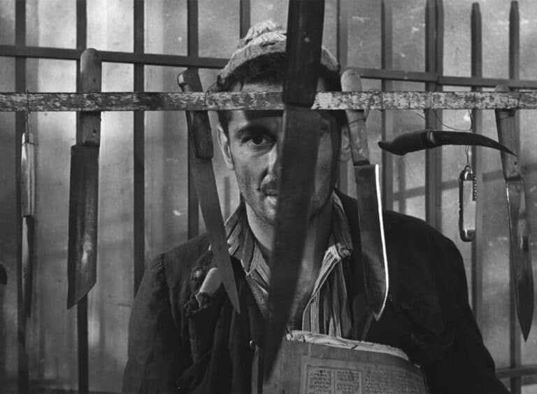 Youssef Chahine as Kenawi, staring at some knives