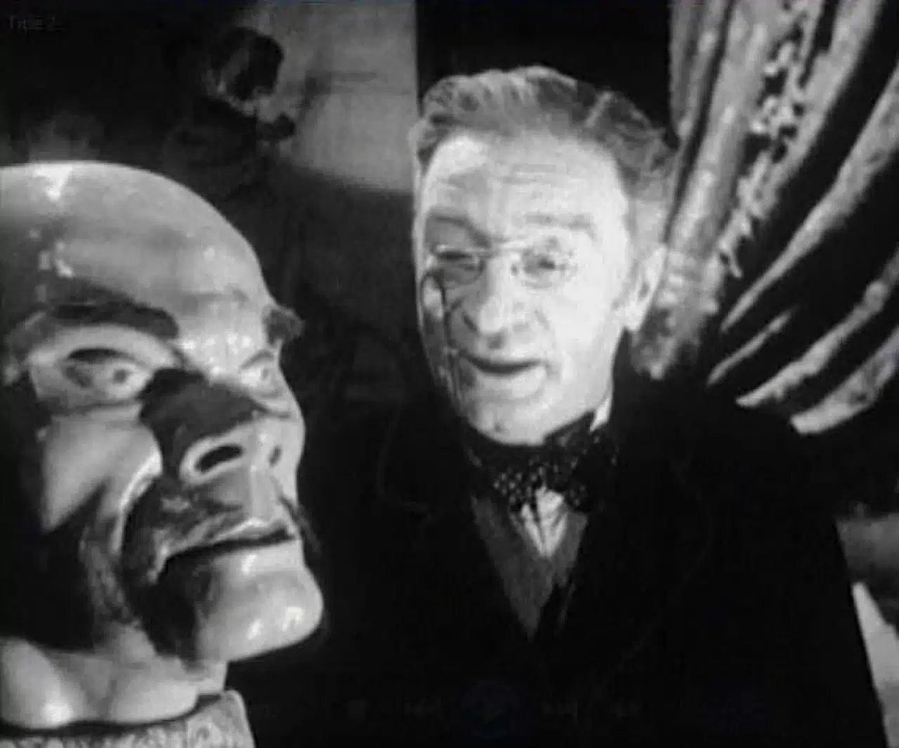 A striking artificial head in the foreground with a narrator speaking