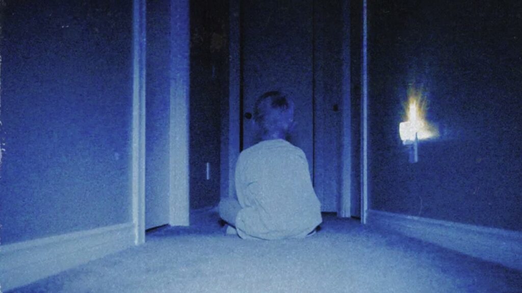 A blurred image of a seated child with back to camera
