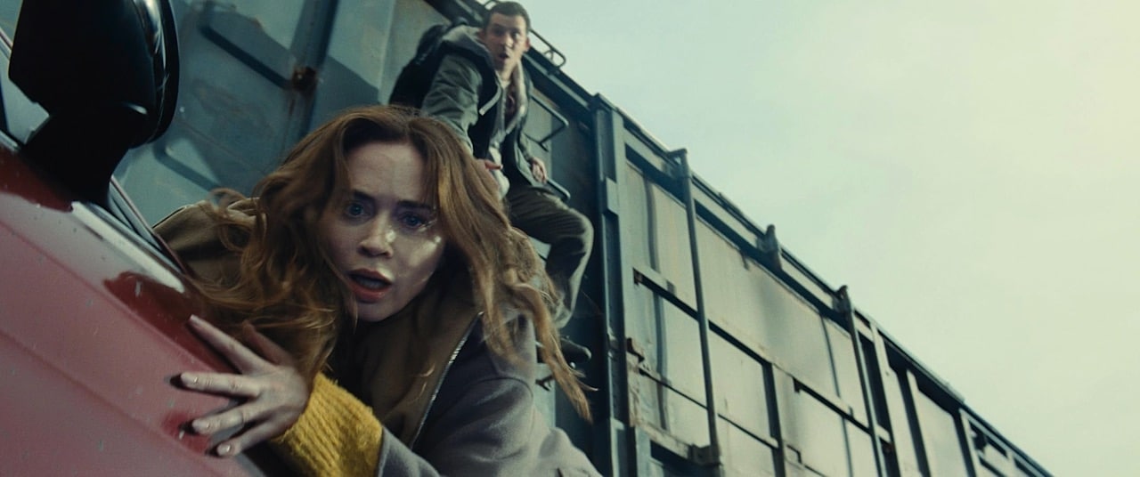 Emily Blunt hangs off a car, with Josh O'Connor trying to save her